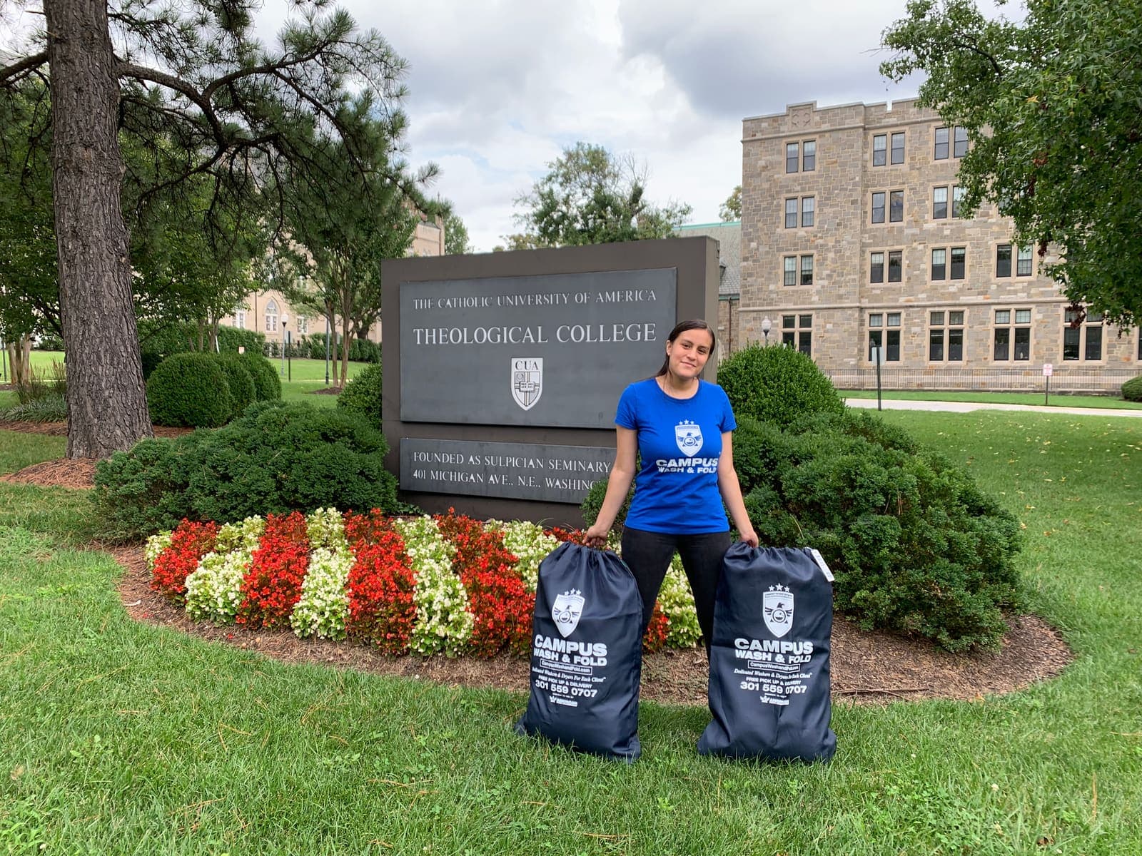 Campus Wash and Fold ambassador holding two branded laundry bags outside Catholic University of America in Brookland, Washington DC