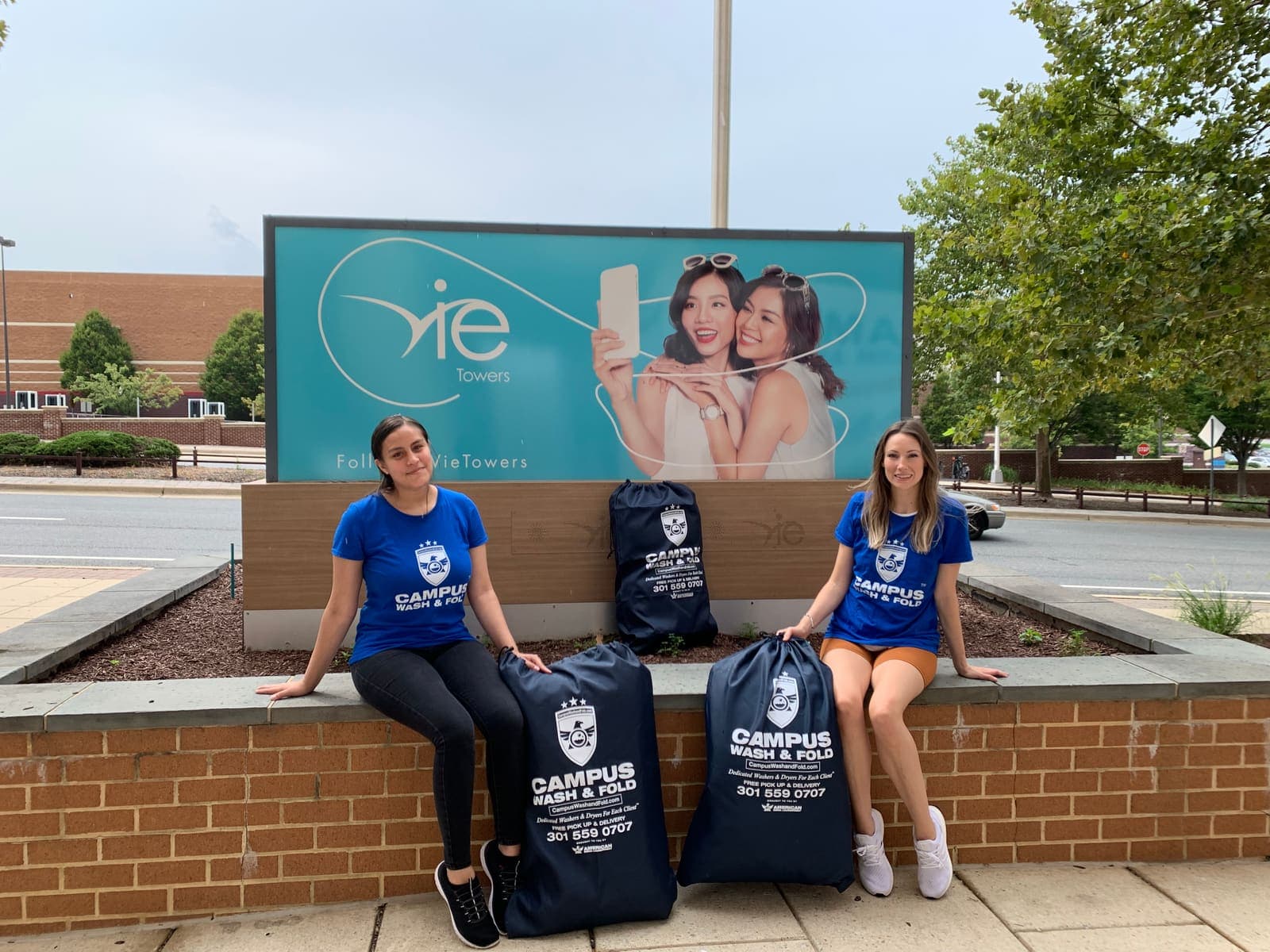 Campus Wash and Fold ambassadors posing with branded laundry bags outside Vie Towers near George Washington University in Foggy Bottom, Washington DC