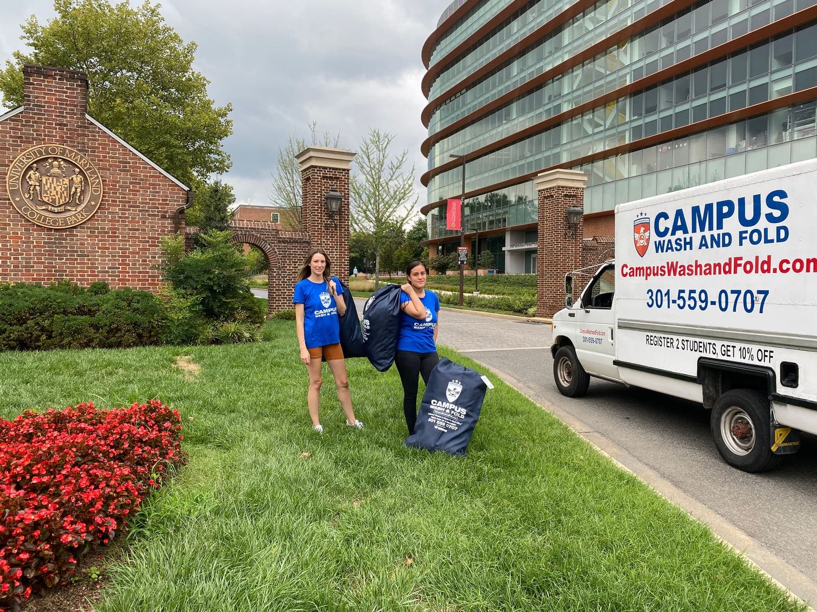 Campus Wash and Fold ambassadors with branded laundry bags next to the Campus Wash and Fold van at the University of Maryland in College Park, Maryland
